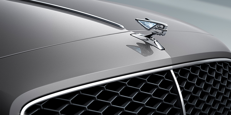 Feser-Graf Exclusive Cars GmbH | Bentley Nürnberg New Bentley Flying Spur sedan bonnet detail in Silverlake paint with Illuminated Flying B bonnet badge and matrix grille with chrome surround