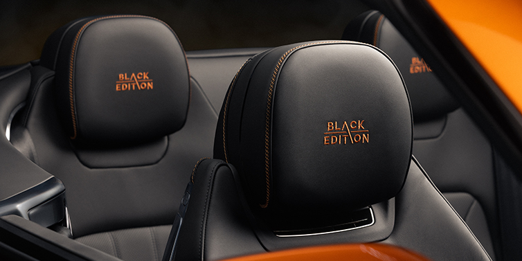 Feser-Graf Exclusive Cars GmbH | Bentley Nürnberg Bentley Continental GTC Black Edition convertible seat detail with Beluga black hide and Mandarin emblem stitching